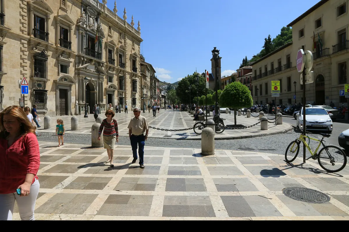 Plaza Nueva у Гранаді сонячного дня: ліворуч — кам'яний фасад Real Chancillería, попереду — церковна вежа Santa Ana
